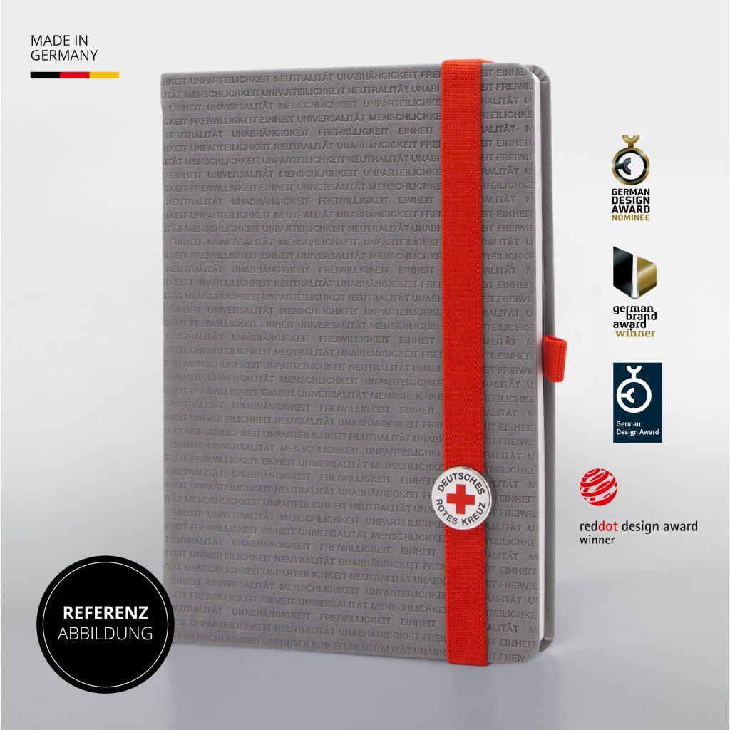 Hellgraues Notizbuch mit wiederholtem Schriftmuster zu humanitären Werten, rotem Lanyband und Deutsches Rotes Kreuz Logo Button, Referenzabbildung mit Design Awards