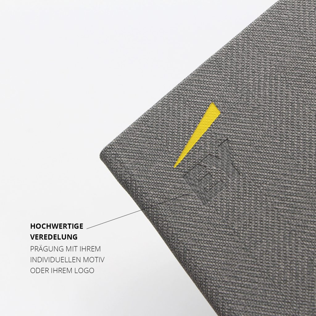 Detailansicht der hochwertigen Blindprägung mit individuellem Logo auf Tweed-Notizbuch-Cover