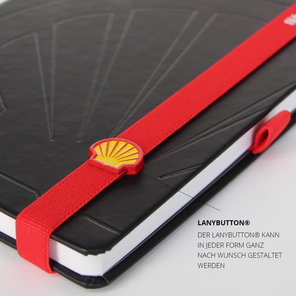 Detailaufnahme des individuellen LanyButtons in Muschelform mit Shell Logo auf rotem Lanyband