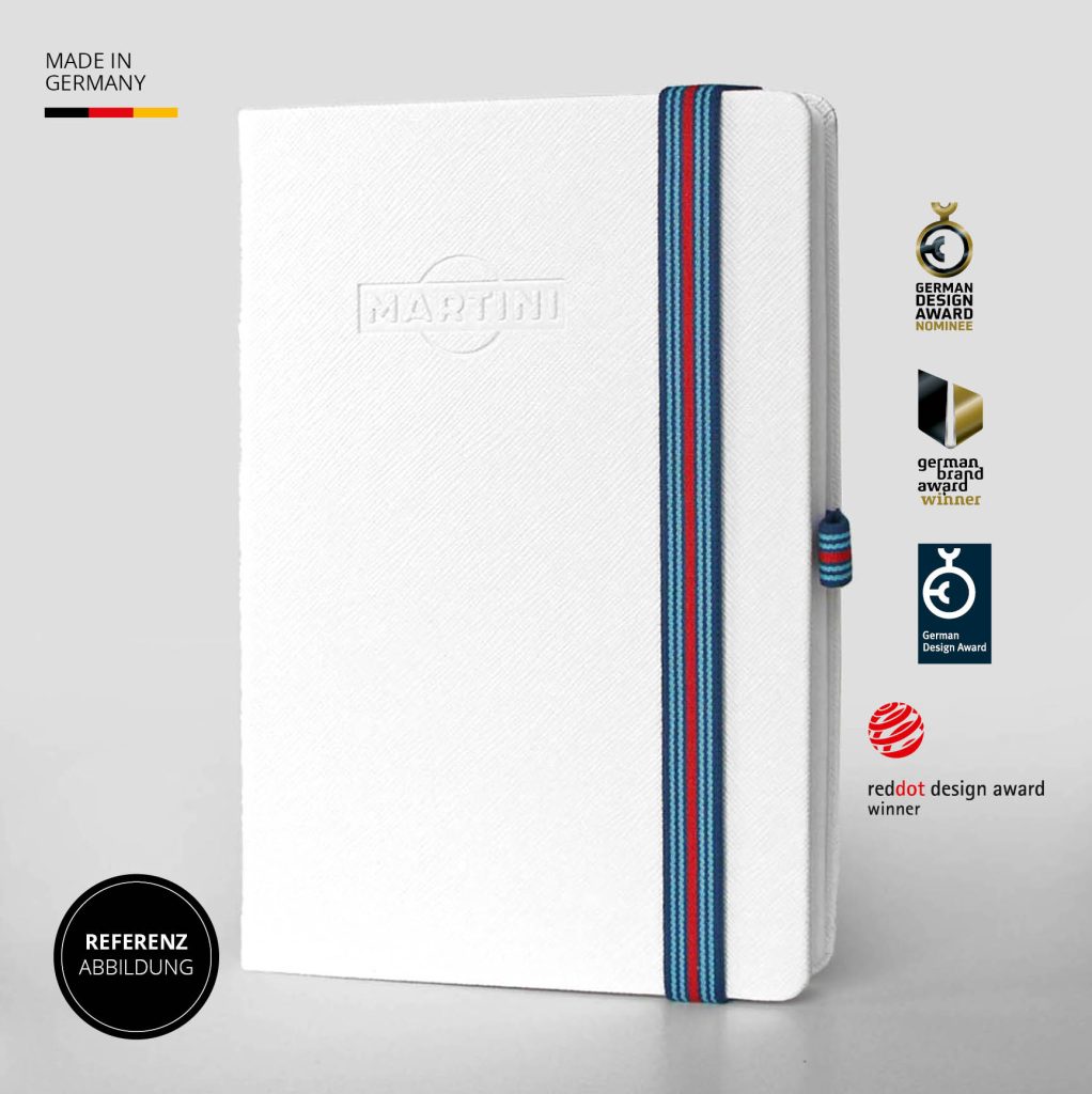 Weißes Notizbuch mit eleganter Martini Blindprägung, hellem Lanyband und Logo Button, Referenzabbildung Made in Germany mit Designauszeichnungen