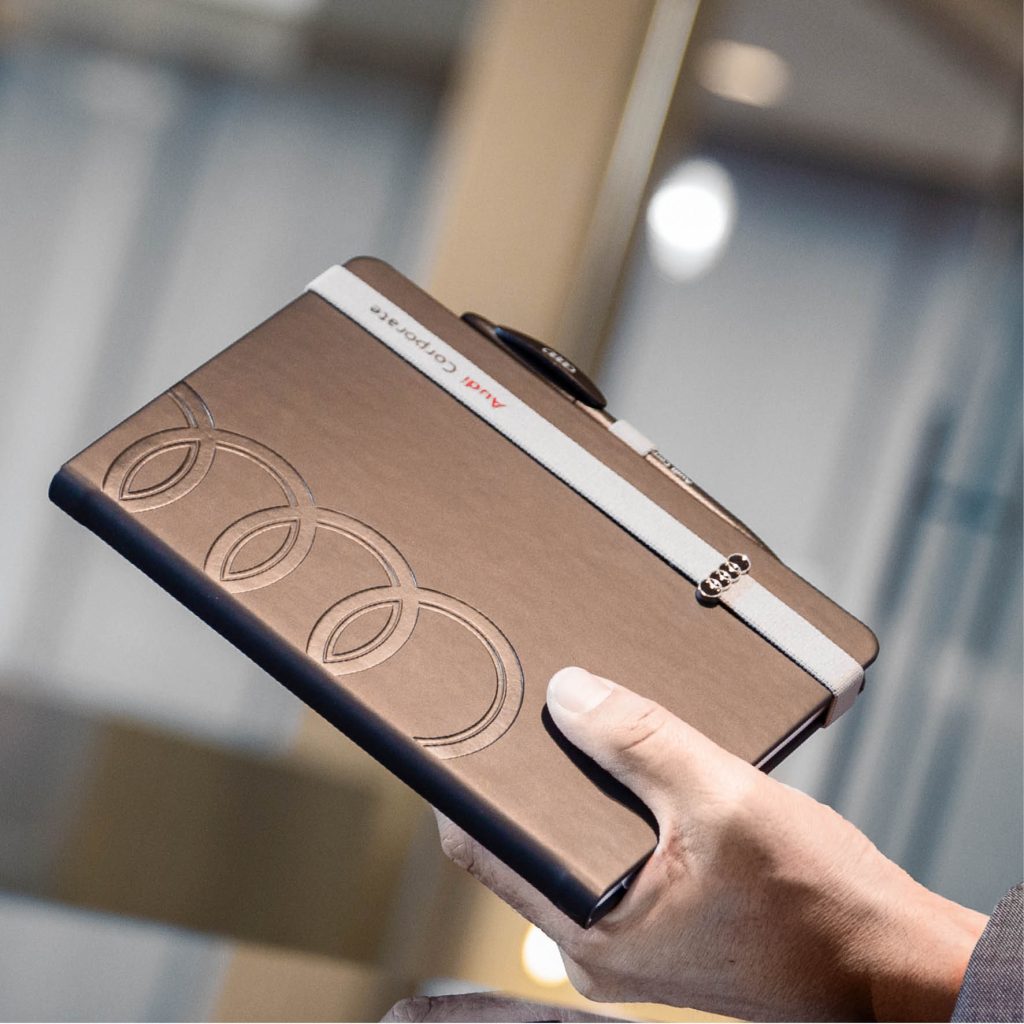 Personalisiertes Lanybook® Notizbuch für Audi in Braun mit geprägtem Logo und farblich abgestimmtem Lanyband im Premium Corporate Design